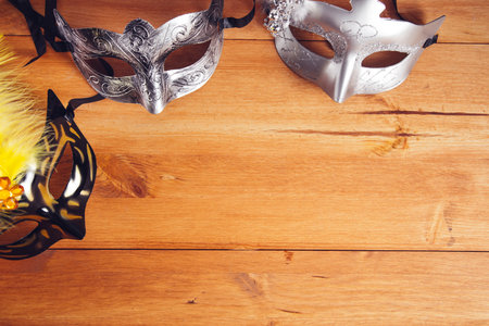 color masquerade masks on a wooden table backgroundの写真素材