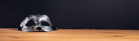 masquerade mask on a wooden table backgroundの写真素材