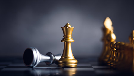 chess piece stand in front of pawn on black backgroundの写真素材
