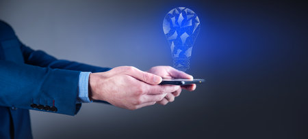 man holding tablet with light bulb graphicsの写真素材