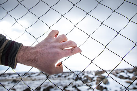 man hand in cage winter nature backgroundの写真素材