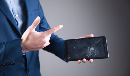 Business man holding broken screen tablet.の写真素材