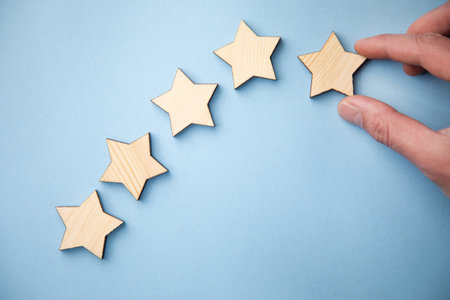 man holding wooden stars on blue table