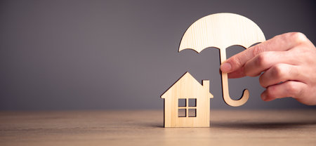 man holding wooden umbrella and house modelの写真素材