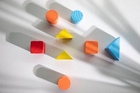 Colorful wooden geometric shapes pattern on white backgroundの写真素材