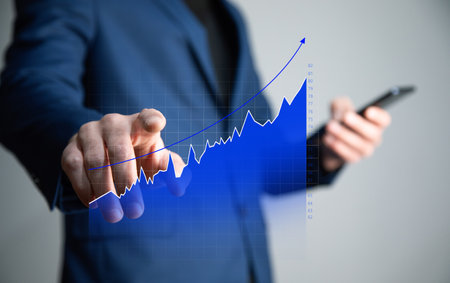 Man holding phone with growth graph.の写真素材