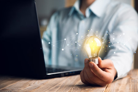 Hand with a lightbulb with a computer, idea concept