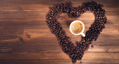 Coffee in coffee beans as a heart on wooden backgroundの写真素材