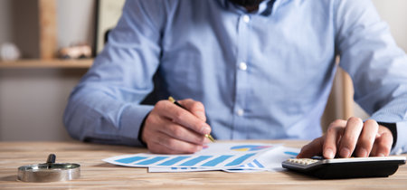 man working in calculator and graph in officeの写真素材