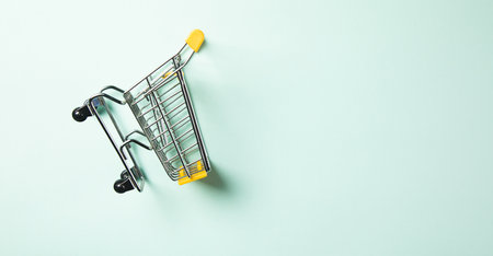 Yellow shopping cart on the blue tableの写真素材