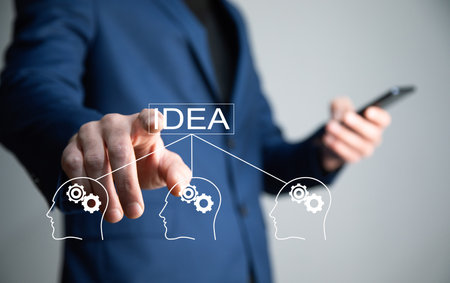 man holding phone with idea and people gears iconの写真素材