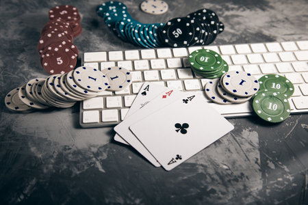 aces with poker chips and keyboard on gray background