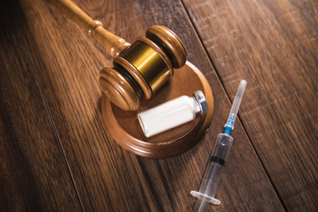 ampoules and syringe with judge, law concept.の写真素材