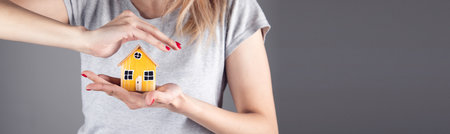 real estate, woman holding wooden house modelの写真素材