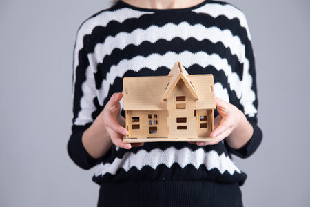 Hands of young woman holding model house.の写真素材