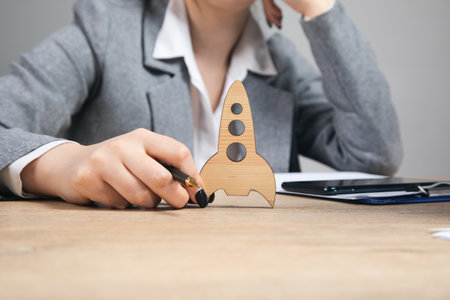 success concept, women holding a wooden rocket