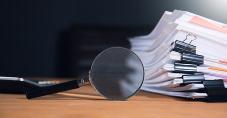 Stack of report paper documents with magnifying glass. Concept of business and search.