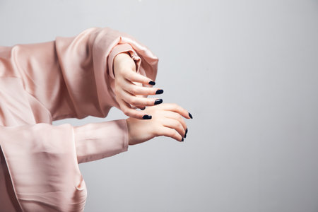 Beautiful female hand with manicure nails isolated on gray backgroundの写真素材