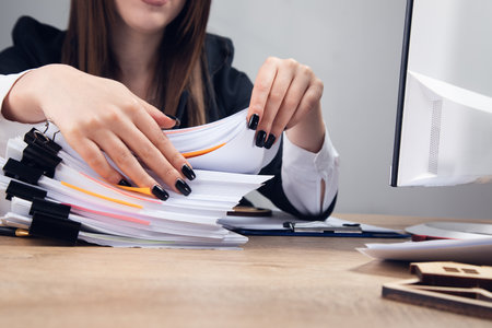 woman holding stack of business documents on table