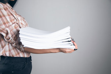 young business woman holding stack of papers