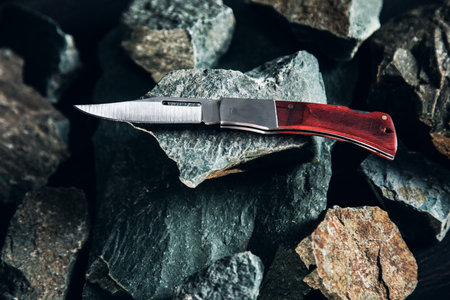 Pocket knife on stone background close up