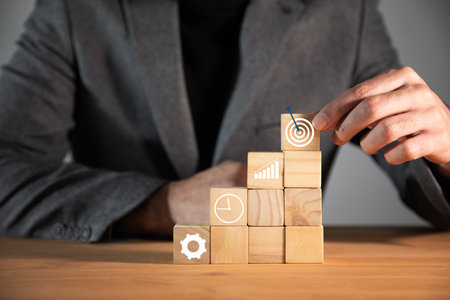 man holding wooden cubes with target sign
