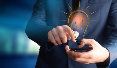 man holding phone with idea or bulbの写真素材