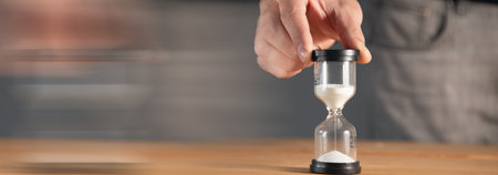 Businessman holding hourglass in the office.