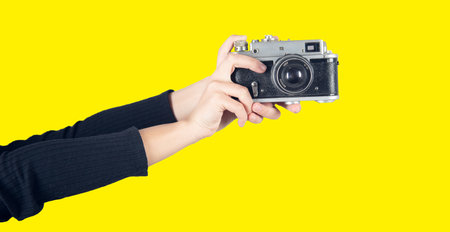 Vintage Camera in female hand. Colored background