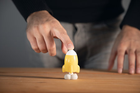 the business man holding rocket on wooden background