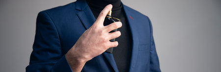 Handsome young business man using perfume.