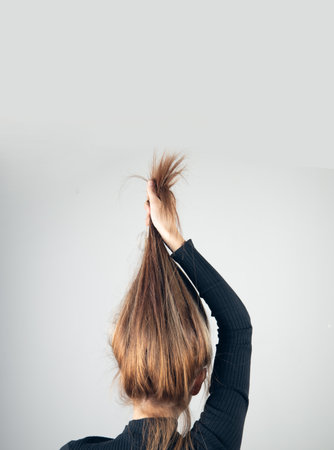 The attractive young woman pulling her hair.