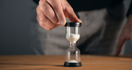 Businessman holding hourglass in the office.