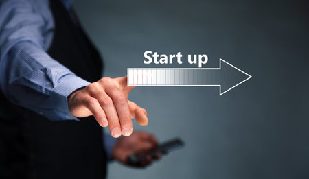 Businessman holding a phone with Start-up text on virtual screen
