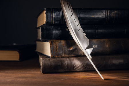 Feather with books on the wooden tableの写真素材