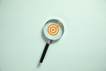 Target inside of magnifier glass on blue backgroundの写真素材