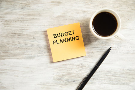budget planning text on paper with cup of coffeeの写真素材