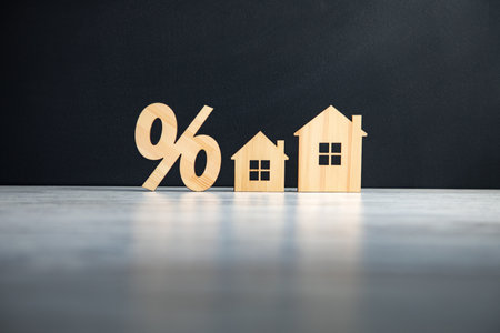 Relocation and house hunting concept. Model of wooden house with sign percentの写真素材
