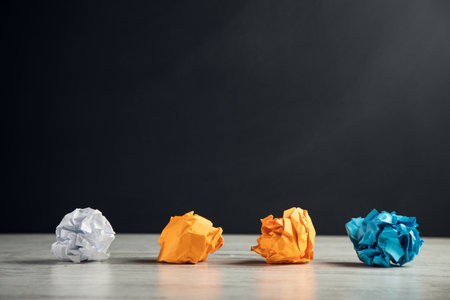 Colorful crumpled paper on a wooden table backgroundの写真素材