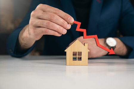 man holds arrow to down with house, The houses are decreasingの写真素材