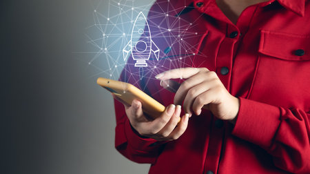 Startup and company growth concept. Woman holding phone and rocket icon