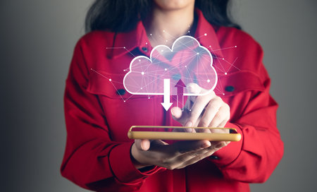 A smartphone connecting to a cloud computing system. Close-up of hand holding a mobile phoneの写真素材
