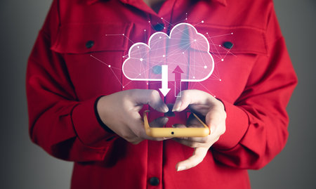 A smartphone connecting to a cloud computing system. Close-up of hand holding a mobile phoneの写真素材