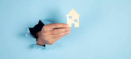 Home insurance concept.Businessman holding home model.の写真素材