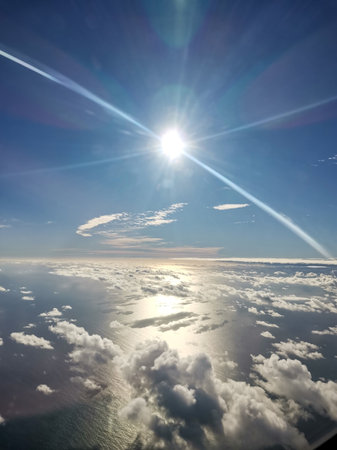 Shining sun with glare on background of horizon. Natural background connection of water and sky. Bokeh rays of sun diverge in different directionsの写真素材