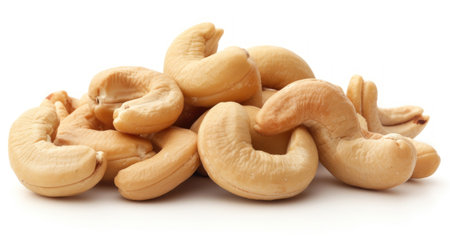 Handful of cashew nuts closeup isolated on white background. Roasted nuts on the table. Healthy organic food. Salty healthy nutritious snackの素材