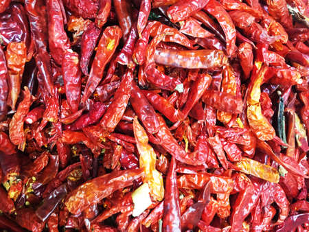 Dried red hot chilli peppers on old wooden table background.の写真素材