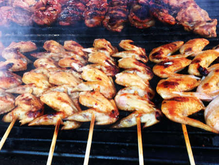The concept of food on the grill. Chicken wings cooked on coals close up.の写真素材