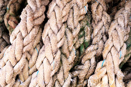 Close-up of an old frayed boat rope as background. Texture of heavy duty cable. Use for marine background. Background of rope.の写真素材