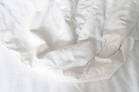 Unmade bed; wrinkled pillowcases, bed sheet and duvet.